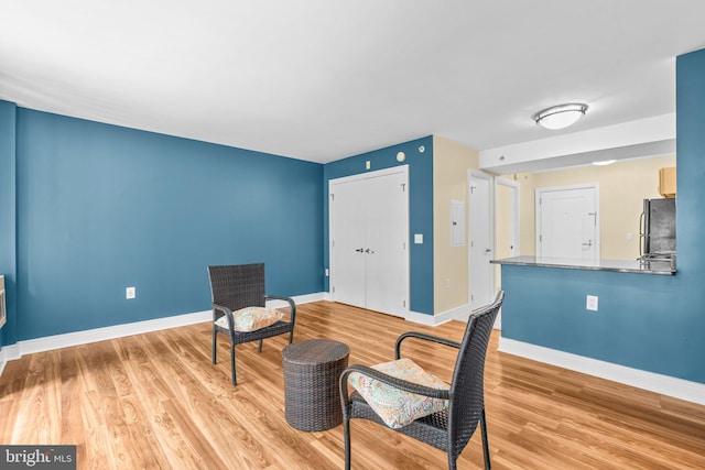 living area featuring light wood-type flooring and baseboards