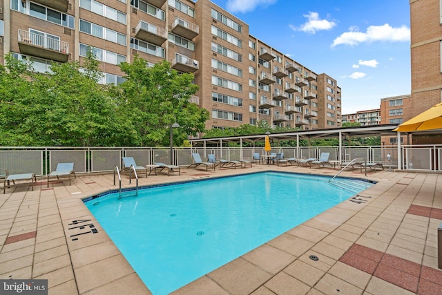 pool with a patio and fence