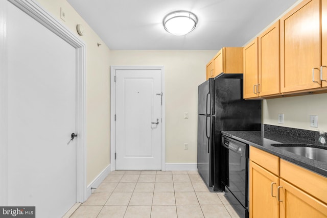 kitchen featuring dark stone counters, light tile patterned floors, dishwasher, light brown cabinetry, and sink