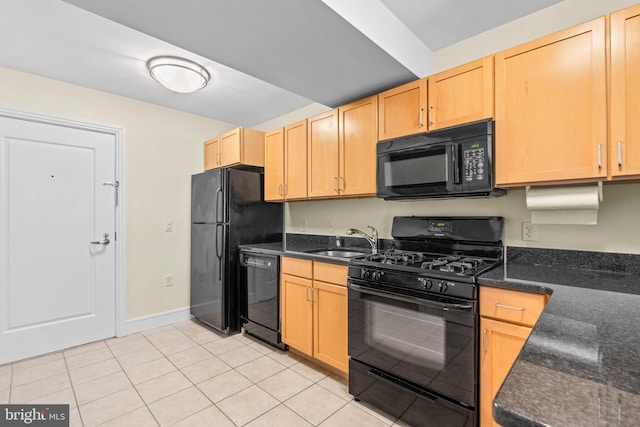 kitchen featuring light tile patterned flooring, light brown cabinets, a sink, black appliances, and dark stone countertops