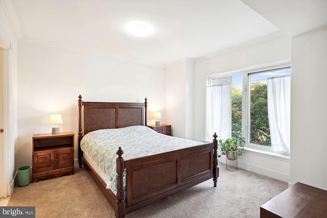 bedroom with ornamental molding and light carpet