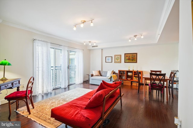 living room with rail lighting, plenty of natural light, dark hardwood / wood-style floors, and crown molding