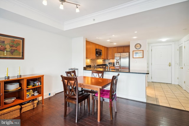 dining area with track lighting, hardwood / wood-style flooring, and sink