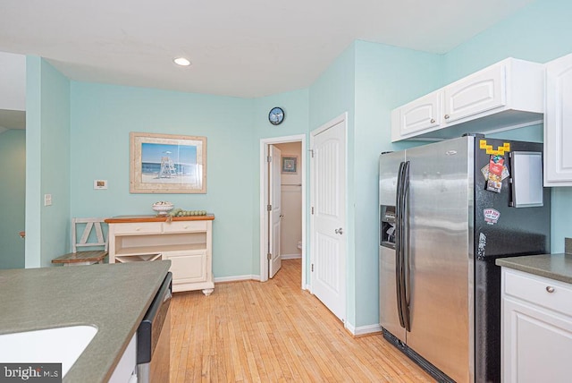 kitchen with white cabinets, appliances with stainless steel finishes, and light wood-type flooring