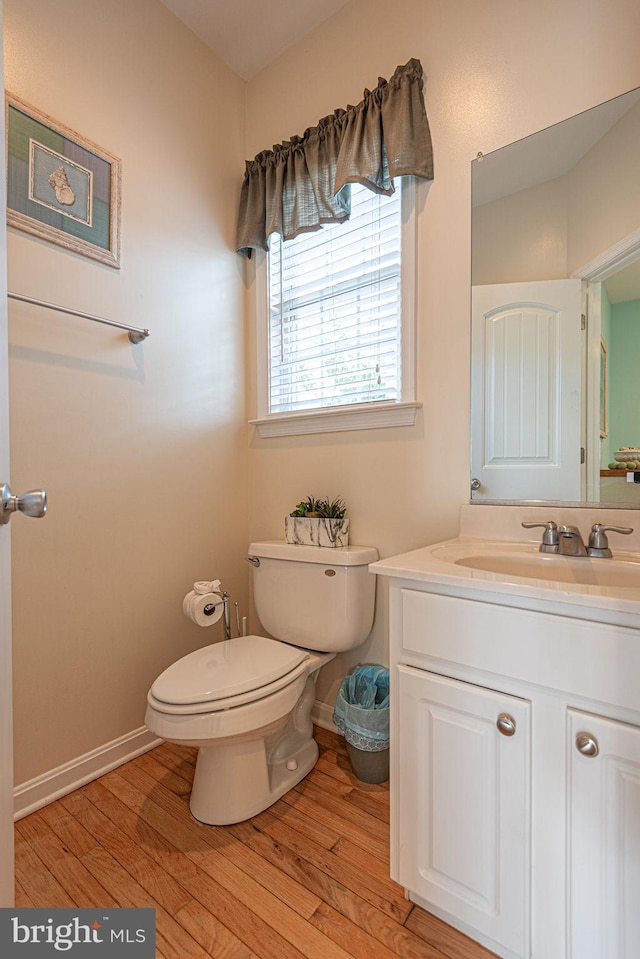 bathroom featuring hardwood / wood-style flooring, toilet, and vanity