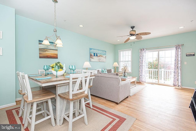 dining area featuring ceiling fan with notable chandelier and light wood-type flooring