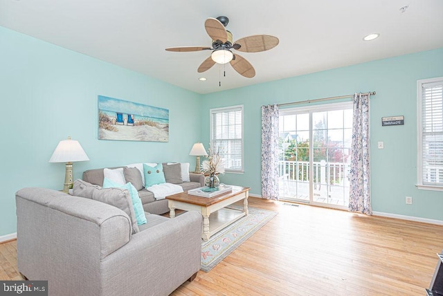 living room with ceiling fan, light hardwood / wood-style flooring, and a healthy amount of sunlight