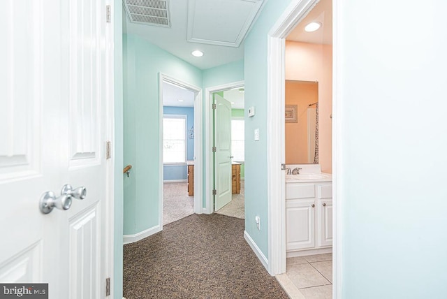 corridor featuring sink and light carpet