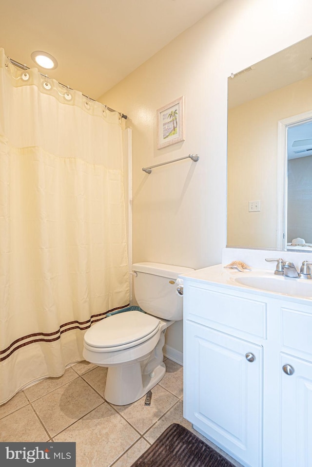 bathroom with a shower with shower curtain, vanity, toilet, and tile patterned floors