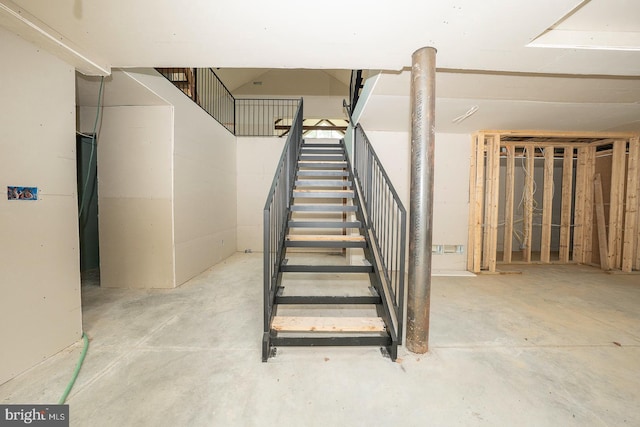 stairs with unfinished concrete flooring