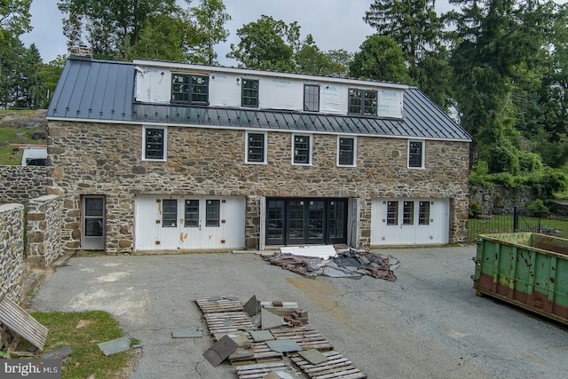 view of front of house with metal roof, a patio, french doors, and a standing seam roof