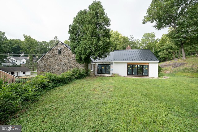 rear view of property featuring a yard