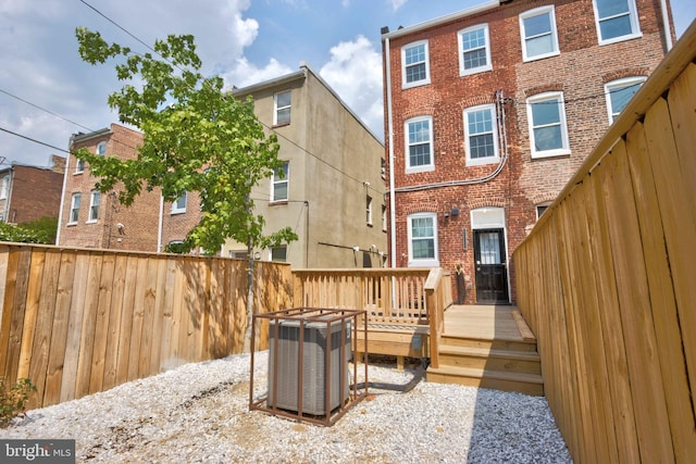 rear view of property featuring a deck and cooling unit