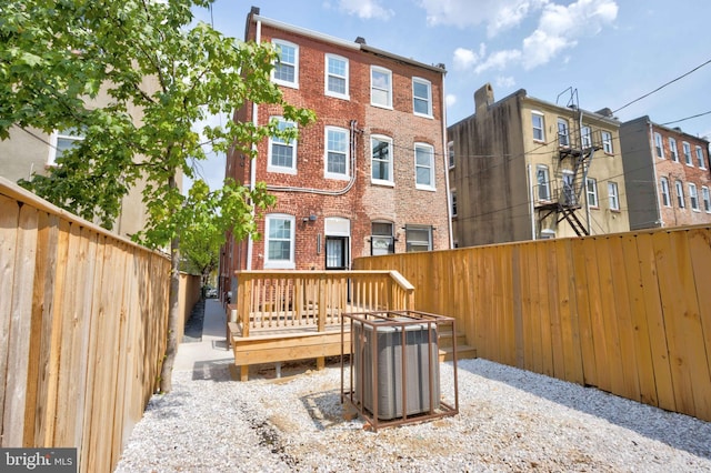 rear view of property with a wooden deck and central AC unit