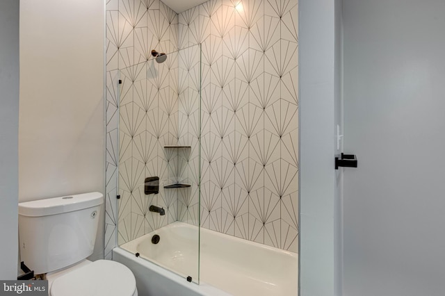 bathroom featuring tiled shower / bath combo and toilet