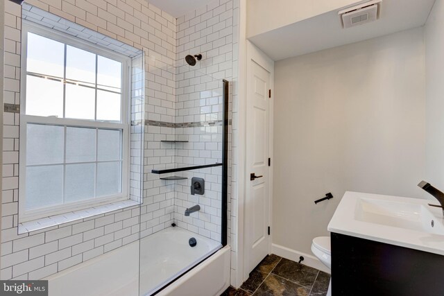 full bathroom with tiled shower / bath combo, toilet, tile patterned flooring, and a healthy amount of sunlight