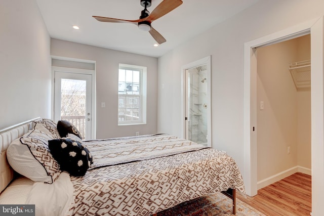 bedroom with ceiling fan, light wood-type flooring, and ensuite bath