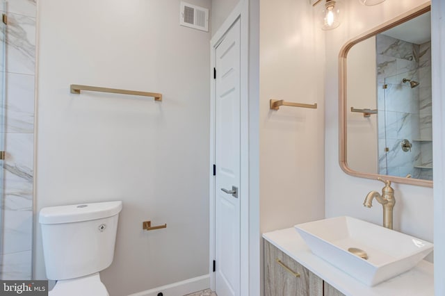 bathroom featuring sink, toilet, and a tile shower