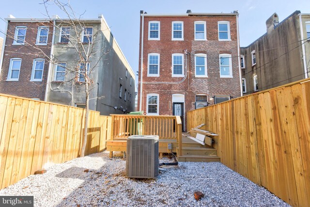 rear view of house featuring central air condition unit and a deck