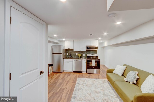 living room featuring sink and light hardwood / wood-style floors