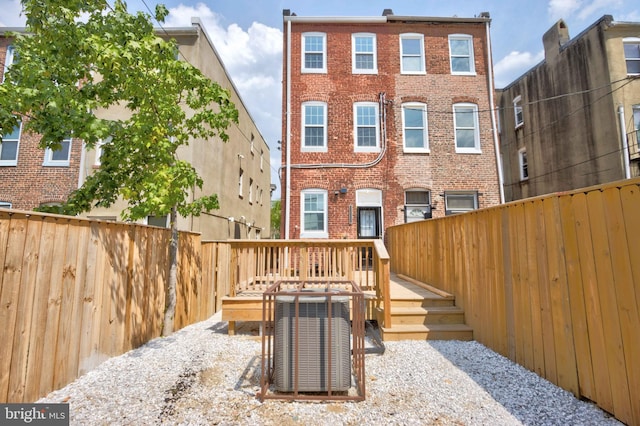 rear view of house featuring central AC and a wooden deck