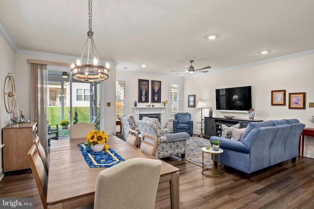 dining space featuring ceiling fan with notable chandelier, dark hardwood / wood-style flooring, and ornamental molding