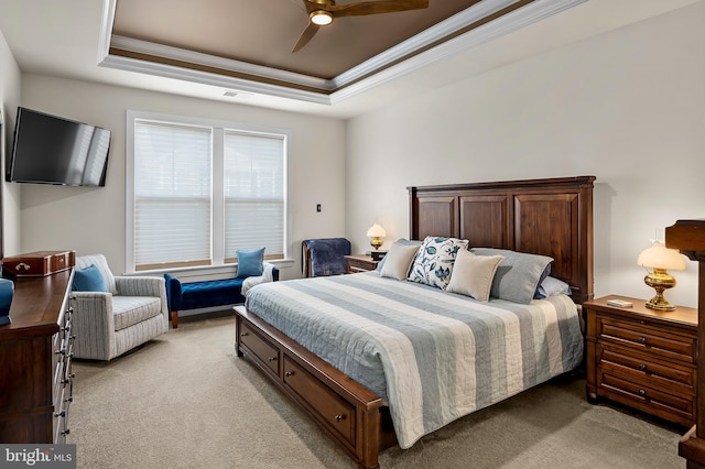 carpeted bedroom featuring ceiling fan, a raised ceiling, and ornamental molding