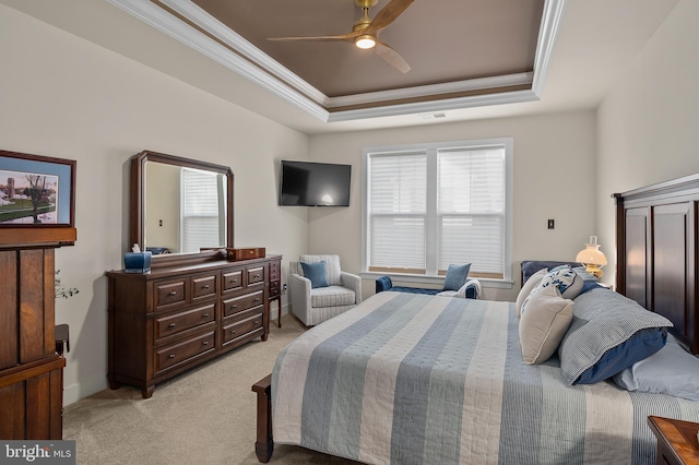 carpeted bedroom featuring crown molding, a raised ceiling, and ceiling fan