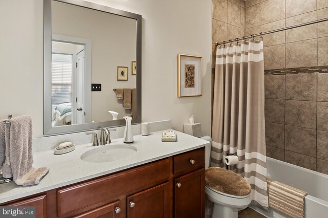 full bathroom featuring shower / bath combo, toilet, and vanity