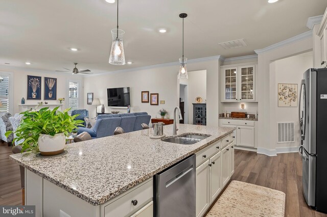 kitchen featuring wood-type flooring, a kitchen island with sink, stainless steel appliances, sink, and ceiling fan