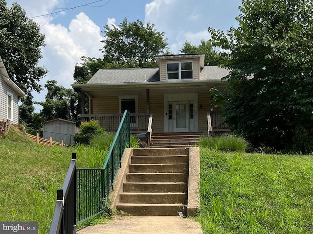 bungalow-style home featuring covered porch, a shed, and a front lawn