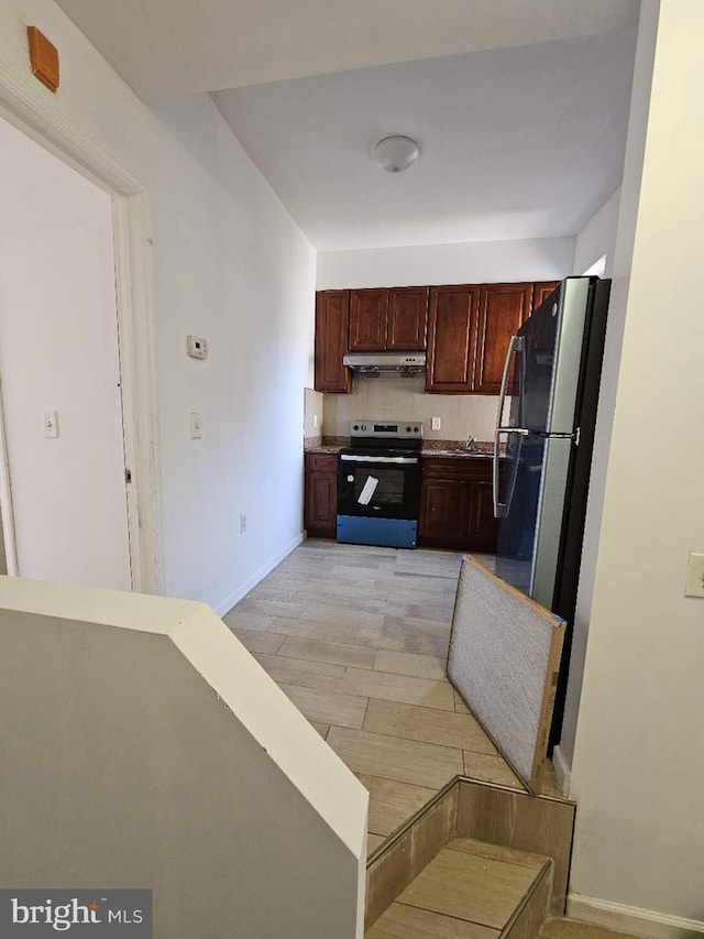 kitchen featuring appliances with stainless steel finishes, decorative backsplash, and light wood-type flooring