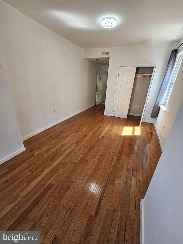 unfurnished bedroom with a closet and hardwood / wood-style floors