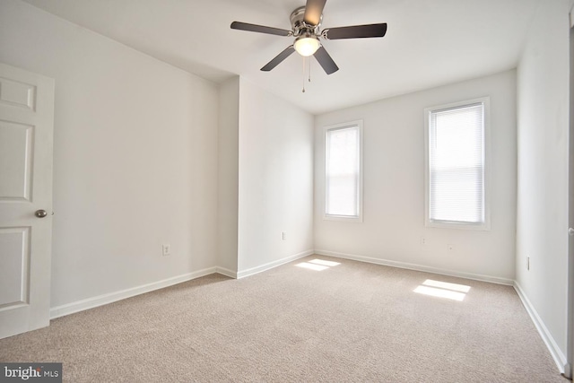 carpeted spare room with ceiling fan