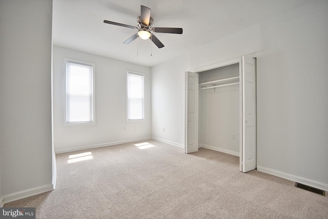 unfurnished bedroom with light carpet, ceiling fan, and a closet