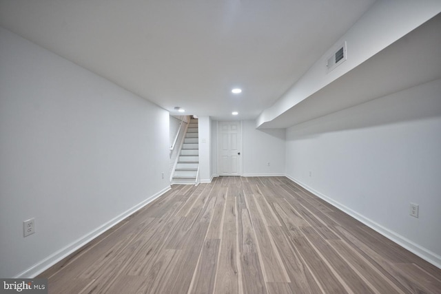 basement with light hardwood / wood-style flooring