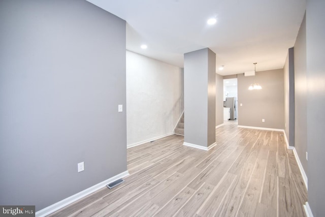 interior space with a notable chandelier and light wood-type flooring