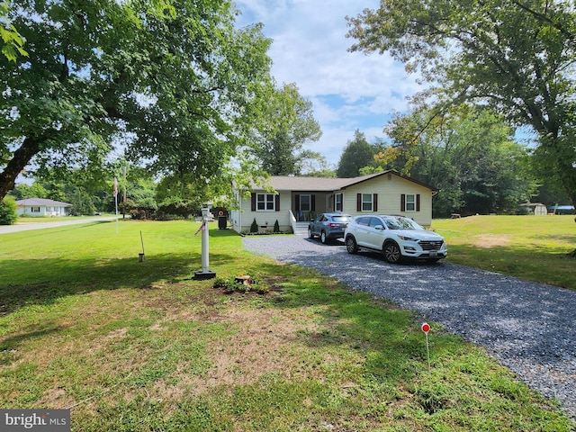 ranch-style home with driveway and a front yard