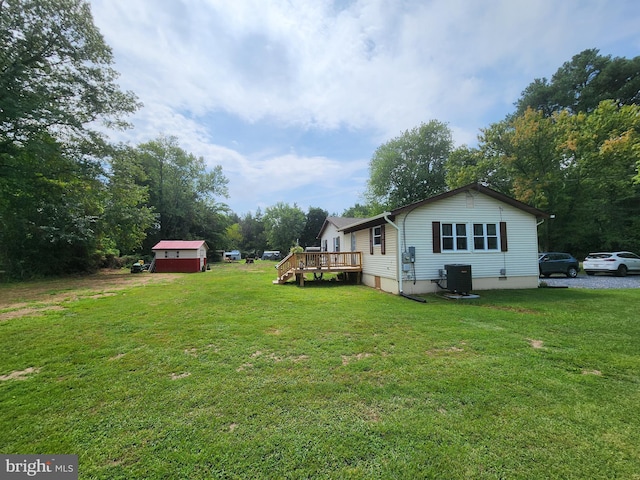 view of yard featuring central AC unit and a deck