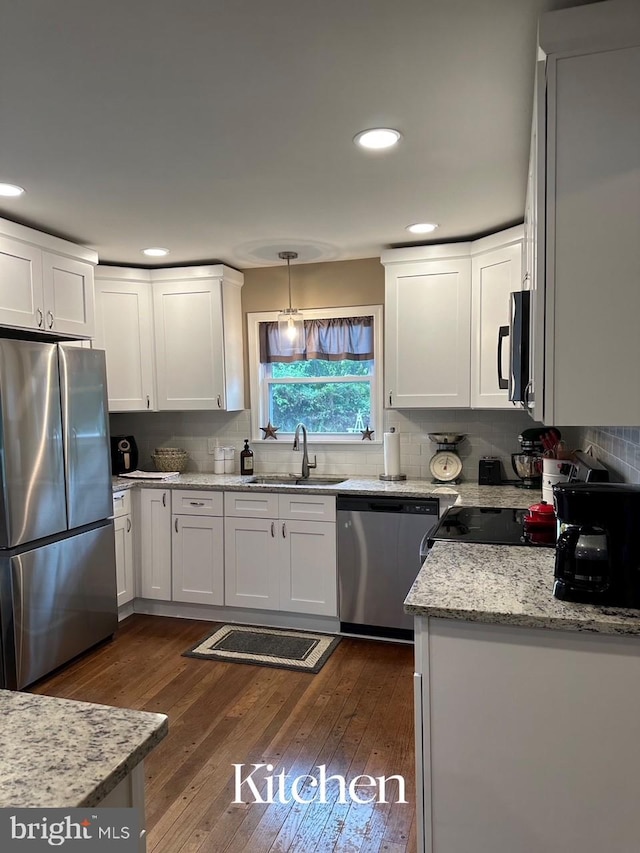 kitchen with backsplash, dark wood-style floors, appliances with stainless steel finishes, and a sink