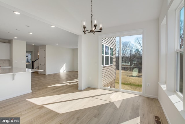 unfurnished dining area featuring a chandelier, light wood finished floors, visible vents, and recessed lighting