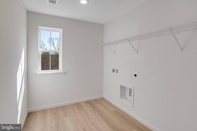 clothes washing area featuring hookup for a washing machine, light wood-style flooring, electric dryer hookup, laundry area, and baseboards