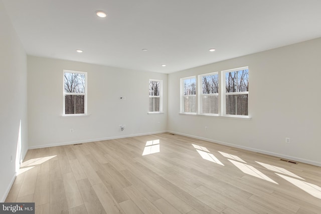 spare room with light wood-style floors, recessed lighting, visible vents, and baseboards