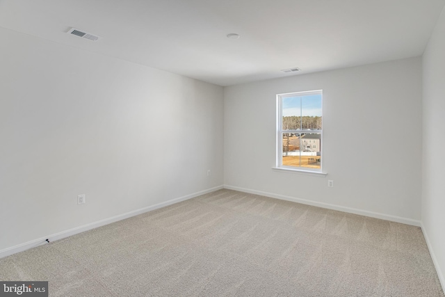 empty room with carpet flooring, visible vents, and baseboards