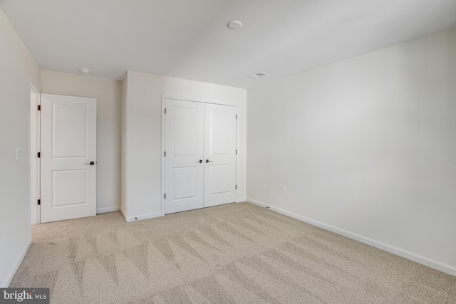 unfurnished bedroom featuring carpet, a closet, visible vents, and baseboards