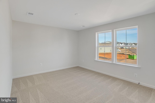 carpeted spare room featuring baseboards