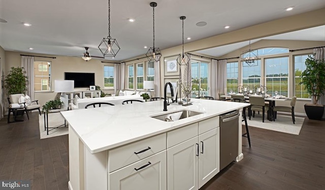 kitchen featuring a kitchen island with sink, a sink, open floor plan, dark wood finished floors, and decorative light fixtures