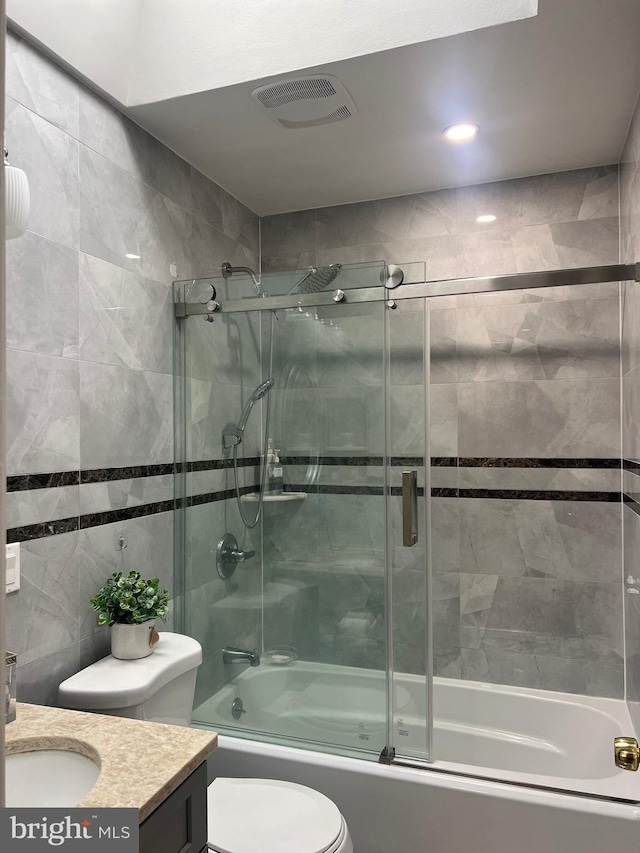 full bathroom with vanity, shower / bath combination with glass door, and toilet