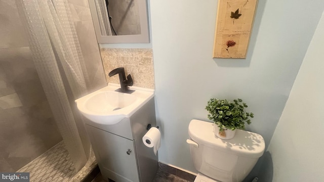 bathroom with a shower with shower curtain, backsplash, vanity, and toilet