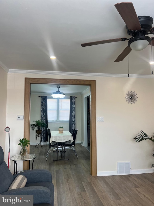 dining area with ceiling fan, ornamental molding, and wood-type flooring